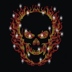 Pode incluir: Uma caveira preta com um design vermelho e amarelo flamejante ao redor. A caveira é feita de strass e tem um acabamento brilhante.