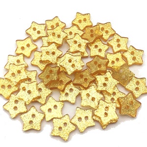 Könnte beinhalten: Ein Haufen goldener Sternknöpfe mit Glitzer.