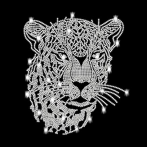 Könnte beinhalten: Ein weißes Strass-Design eines Leopardenkopfes mit funkelnden Akzenten.