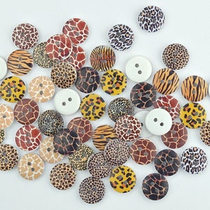 Könnte beinhalten: Sortiment runder Holz-Knöpfe mit verschiedenen Tiermuster-Designs, darunter Leopard, Zebra, Giraffe und Gepard. Die Knöpfe sind in Braun-, Schwarz-, Weiß- und Gelbtönen gehalten.