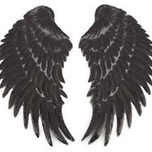 Può includere: Un paio di ali d'angelo nere con un design a pizzo. Le ali sono fatte di tessuto e hanno un aspetto delicato ed etereo.