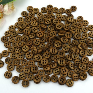May include: A large pile of brown wooden buttons with four holes each. The buttons are arranged in a random pattern.