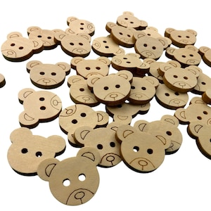 Könnte beinhalten: Ein Haufen Holz-Knöpfe mit einem Bärenkopf-Design. Die Knöpfe sind hellbraun und haben jeweils zwei Löcher.