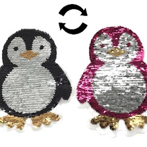 Könnte beinhalten: Zwei reversible Pinguin-Patches mit Pailletten. Ein Pinguin ist schwarz mit einem silbernen Paillettenkörper und goldenen Füßen. Der andere Pinguin ist pink mit einem silbernen Paillettenkörper und goldenen Füßen.
