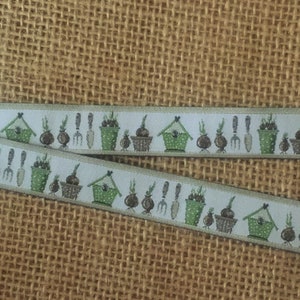 May include: White ribbon with a repeating pattern of green pots, brown bulbs, and small birdhouses. The ribbon has a light beige background.