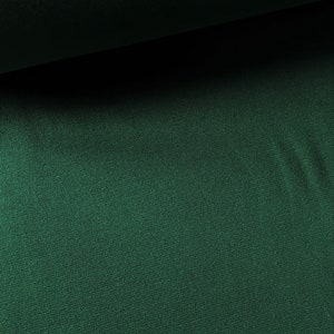 May include: A close-up of a dark green fabric with a subtle texture. The fabric has a smooth, even surface and a rich, deep color.