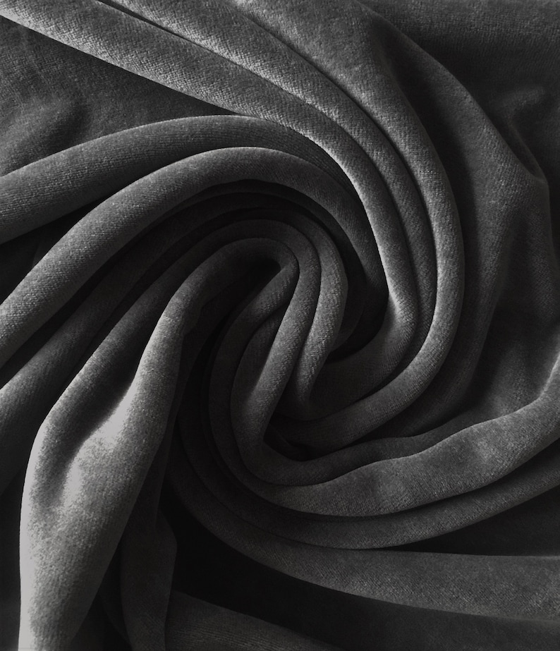 Puede incluir: Primer plano de una tela de terciopelo gris oscuro, que muestra la textura suave y los pliegues del material.