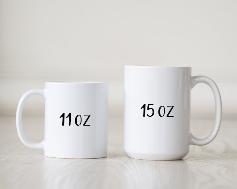 May include: Two white ceramic mugs with black text. The smaller mug is 11 oz and the larger mug is 15 oz.