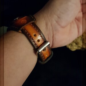 May include: A brown leather watch band with stitching detail and a silver buckle.