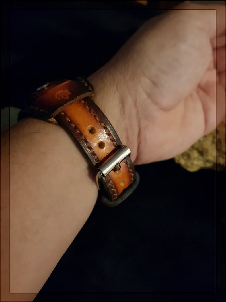 May include: A brown leather watch band with stitching detail and a silver buckle.