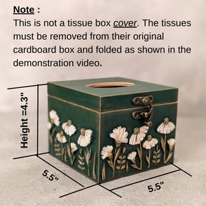 May include: A dark green wooden tissue box with a floral design. The box is 5.5 inches wide and 4.3 inches high. It features a hinged lid and a decorative floral relief. The text on the image says: "This is not a tissue box cover."