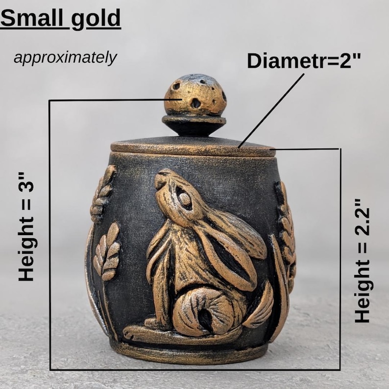 Puede incluir: Peque&ntilde;o tarro decorativo dorado con tapa. El tarro es negro con detalles dorados y presenta un dise&ntilde;o de conejo. El tarro mide aproximadamente 7,6 cm de alto, 5,6 cm de ancho y 5,1 cm de di&aacute;metro.