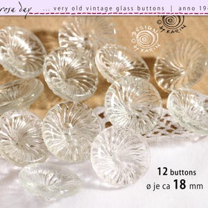 Könnte beinhalten: Zwölf durchsichtige Glasknöpfe mit einem Spiralmuster. Jeder Knopf hat einen Durchmesser von etwa 18 mm. Die Knöpfe sind auf einem weißen Stoffhintergrund angeordnet. Der Text "12 buttons Ø je ca 18 mm" ist in der unteren rechten Ecke des Bildes sichtbar.