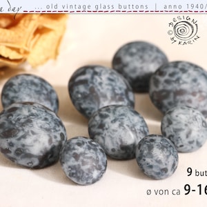 May include: Nine vintage glass buttons with a speckled, mottled appearance in shades of gray and blue. The buttons vary in size, ranging from approximately 0.35 to 0.63 inches in diameter. The text on the image reads "old vintage glass buttons | anno 1940/50/60".