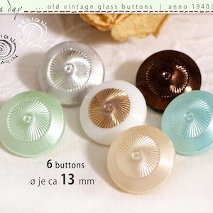 May include: A set of six round glass buttons, each measuring approximately 13 mm in diameter. The buttons feature a radial sunburst pattern and come in various colours, including silver, white with a gold centre, brown, light green, cream, and blue.