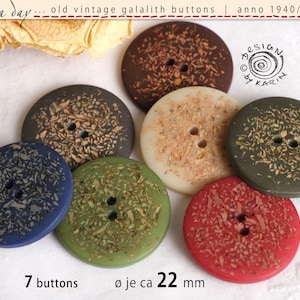 Könnte beinhalten: Sieben vintage Galalith-Knöpfe in verschiedenen Farben, darunter Braun, Creme, Grün, Blau und Rot. Jeder Knopf hat ein gesprenkeltes Muster und zwei Löcher. Die Knöpfe haben einen Durchmesser von etwa 22 mm. Der Text "DESIGN by KARIN" ist in der oberen rechten Ecke des Bildes sichtbar.