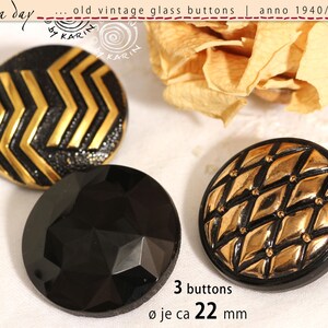 Puede incluir: Tres botones redondos de vidrio con un diámetro de 22 mm. Un botón presenta un patrón de chevrón negro y dorado, uno es negro sólido con una superficie facetada y otro tiene un patrón de rejilla de diamantes dorados sobre una base negra.
