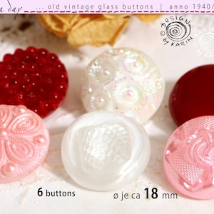 May include: A collection of six vintage glass buttons, each measuring 18 mm in diameter. The set includes a deep red textured button, a translucent white button with a circular pattern, a solid dark red button, a light pink floral button, a smooth white button, and a light pink button with a geometric design.