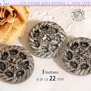 May include: Three vintage silver glass buttons with detailed floral and swirl patterns. Each button is approximately 22 mm in diameter. The image includes text that reads "old vintage glass buttons" and "anno 1940/50/60".
