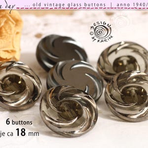 Peut inclure: Six boutons anciens en verre avec un motif tourbillonnant. Les boutons sont de couleur gris fumé et mesurent environ 1,8 cm de diamètre. Le texte sur l'image indique "old vintage glass buttons | anno 1940/50/60".