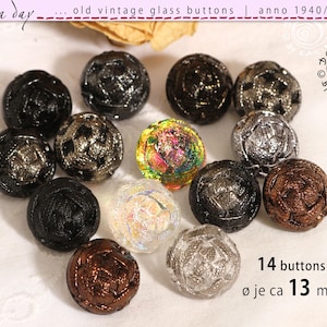 Puede incluir: Una colección de catorce botones de vidrio vintage en varios colores, incluyendo negro, plateado y marrón. Los botones miden aproximadamente 13 mm de diámetro y presentan diseños esféricos texturizados. El texto "old vintage glass buttons" es visible.