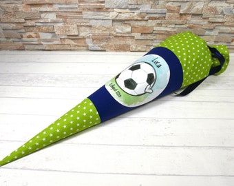 May include: A green and white star-patterned cone-shaped bag with a navy blue band and a soccer ball graphic. The graphic includes the name "Luca" and the date "12 August 2015". The bag is tied with a black ribbon.