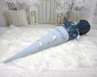 May include: A cone-shaped school gift bag featuring a light blue waffle-textured fabric with embroidered dolphins and a dark blue top section with sea turtle patterns. The name Hannah is embroidered in blue script on the light blue fabric.