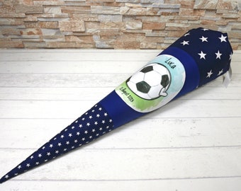 May include: A blue and white school cone with a soccer ball and the name Luca on it. The cone is decorated with white stars on a blue background.