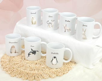 May include: Set of ten white ceramic mugs with animal illustrations and names printed on them. The mugs are arranged on a woven surface.