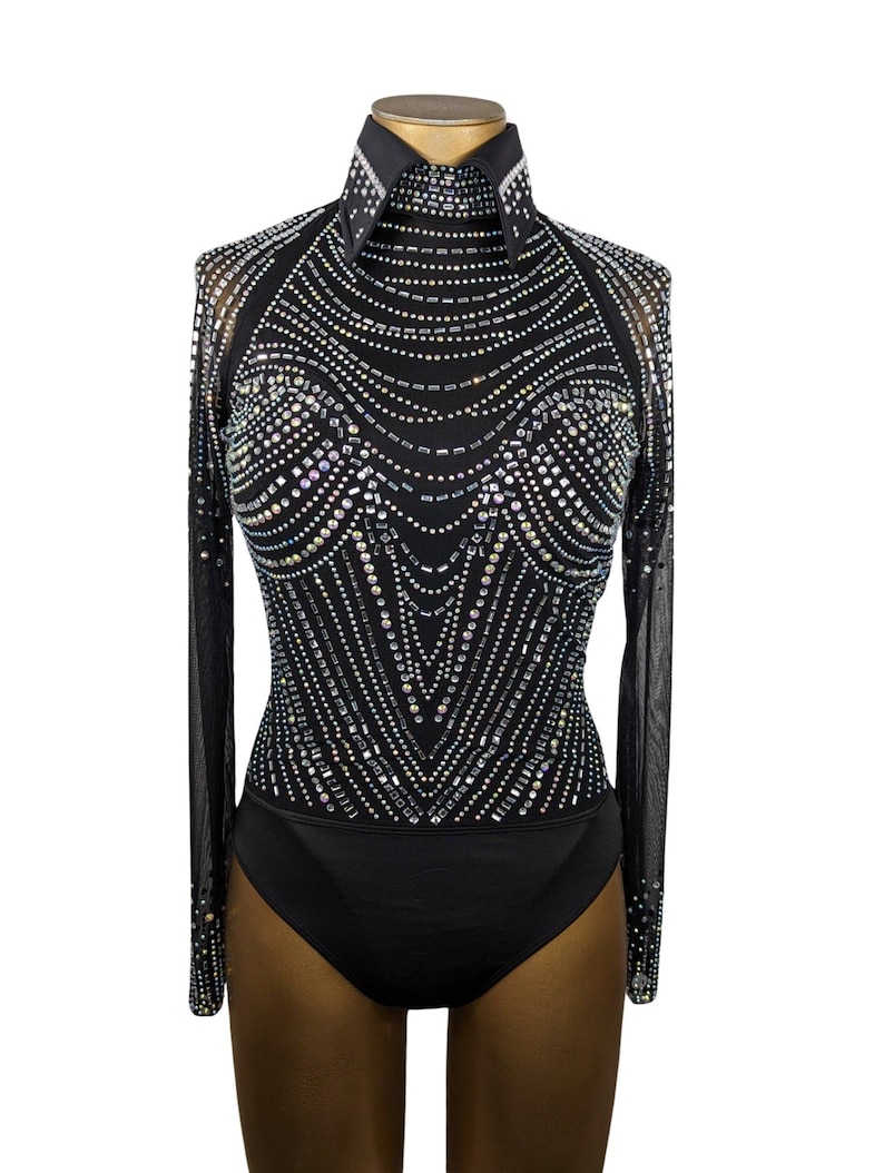 May include: A black long-sleeved bodysuit with a high mock neck and a geometric pattern of iridescent rhinestones.