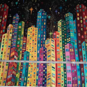 Könnte beinhalten: Ein farbenfroher Stoff mit einem sich wiederholenden Muster aus hohen Gebäuden vor einem schwarzen Hintergrund mit weißen Sternen. Die Gebäude bestehen aus verschiedenen geometrischen Formen und Mustern in Rot-, Gelb-, Blau-, Grün- und Violetttönen.