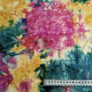 Könnte beinhalten: Abstrakter Batikstoff in einem Farbschema aus Gelb, Rosa und Türkis. Der Stoff hat eine weiche, fließende Textur und einen einzigartigen, handgemalten Look.