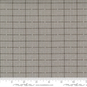 Könnte beinhalten: Ein grauer Stoff mit einem weißen Gittermuster und kleinen schwarzen Punkten. Der Stoff wird in Zoll gemessen, wobei der Text "moda" auf dem Lineal gedruckt ist.