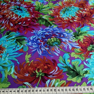 Könnte beinhalten: Lilafarbener Stoff mit einem Blumendruck mit großen blauen und roten Chrysanthemen. Der Stoff hat ein sich wiederholendes Muster aus Blumen und Blättern.