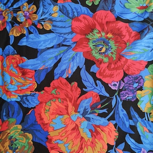 Könnte beinhalten: Ein lebendiger floraler Stoff mit großen roten und orangen Blumen und blauen Blättern auf schwarzem Hintergrund. Das Design umfasst kleinere Blüten in Orange, Grün und Lila. Ein Lineal ist am unteren Rand sichtbar.