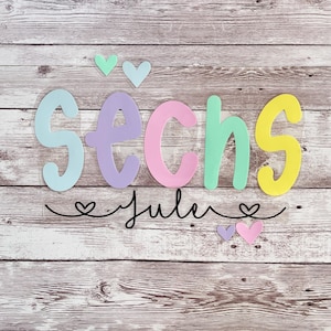 Può includere: Un'opera d'arte di parole colorate con la parola "SECHS" in colori pastello e il nome "Julie" scritto in corsivo con un cuore su ogni lato. Ci sono anche piccoli cuori negli angoli in alto a sinistra e in basso a destra dell'immagine.
