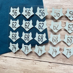 May include: Twenty-five blue fox-shaped stickers with black numbers on them. The numbers are 56, 62, 68, and 74.