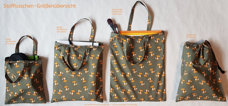 Op de afbeelding: Vier stoffen draagtassen in verschillende maten, elk met een herhaald patroon van oranje vossen op een gedempte groene achtergrond. De tassen omvatten een kleine tas, een middelgrote tas, een grote tas en een trekkoordtas.