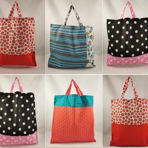 Könnte beinhalten: Sechs Stoff-Tragetaschen mit verschiedenen Mustern. Die Designs umfassen Erdbeeren, Polka Dots, Streifen und Blumendrucke. Jede Tasche hat einen kontrastierenden Boden und passende Griffe. Die Taschen sind zum Tragen von Gegenständen konzipiert.
