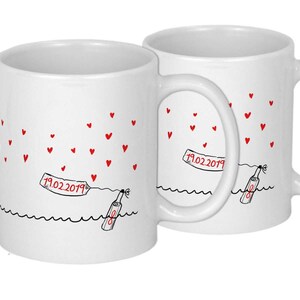Pu&ograve; includere: Due tazze in ceramica bianca con manici neri. Le tazze presentano un'illustrazione in bianco e nero di una bottiglia con un messaggio al suo interno, che galleggia su una linea ondulata. Il messaggio sulla bottiglia dice "19.02.2019". Cuori rossi sono sparsi intorno alla bottiglia.