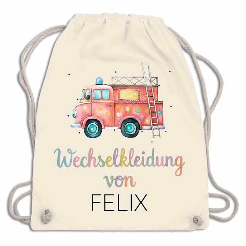 May include: A cream-colored drawstring backpack featuring a watercolor illustration of a pink fire truck with a ladder. The text "Wechselkleidung von FELIX" is written in colorful script below the truck. The bag has gray drawstrings.