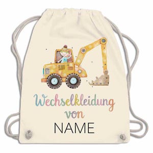 May include: A cream-colored drawstring backpack featuring a yellow excavator with a cartoon driver. The text "Wechselkleidung von NAME" is printed in colorful script below the excavator. The bag has gray drawstrings.