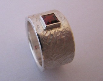 Wide silver ring hammered with garnet