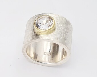 14 mm wide silver ring with white topaz, 9 mm and 18kt. Yellow gold setting