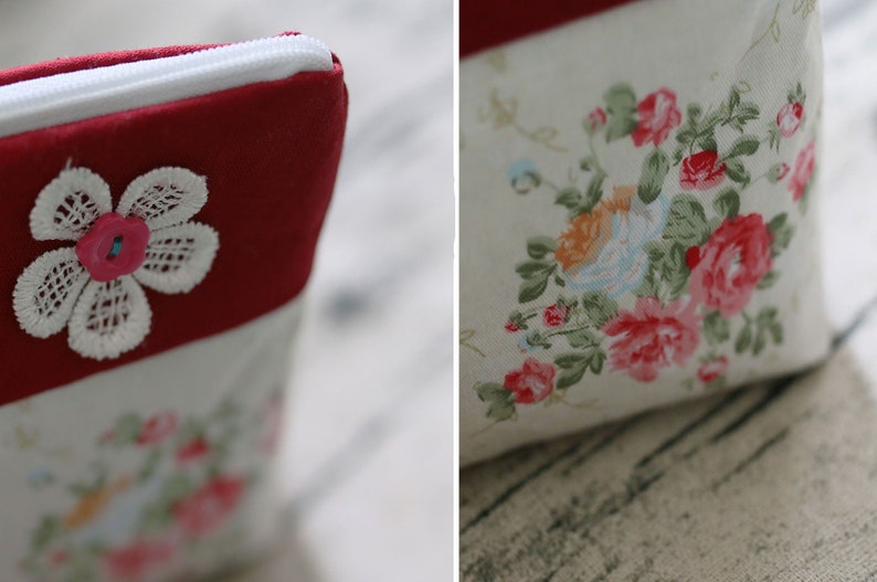 May include: A red and white zippered pouch with a white lace flower and a pink button. The pouch has a floral print on the other side.