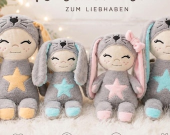 May include: Four plush dolls with grey bunny hoods and long ears. Each doll features a smiling face with freckles and a star applique on the chest. The dolls have accents in yellow, light blue, and pink on their ears, stars, and feet.