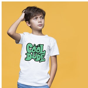 Könnte beinhalten: Ein weißes T-Shirt mit einer grünen Grafik, auf der in einer stilisierten Schrift "Cool Dude" steht.