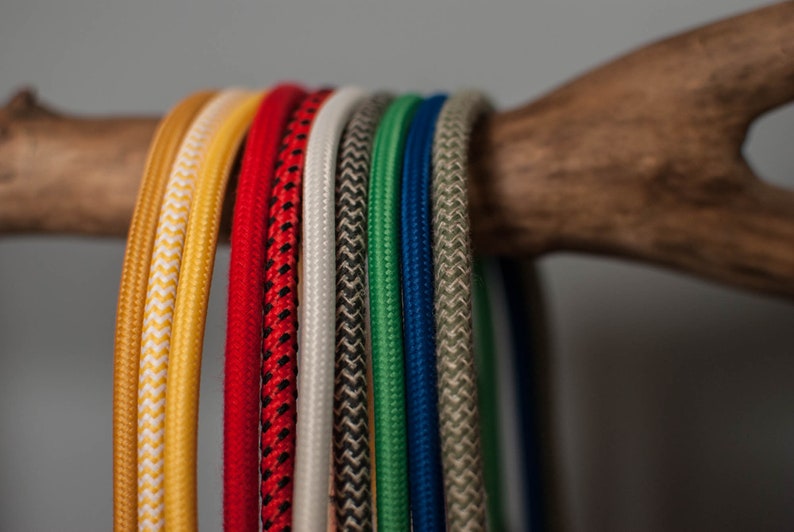 May include: A collection of colorful braided cords in various colors, including yellow, red, white, black, green, blue, and beige.