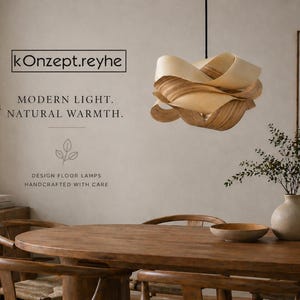 May include: A modern, wooden pendant light hangs above a wooden dining table. The light fixture is made of layered, light-colored wood. The room features a neutral color palette with a vase of greenery and the text "kOnzept.reyhe".