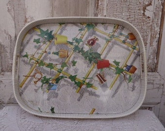May include: A white serving tray with a raised rim and a floral design featuring green leaves, yellow flowers, and brown branches. The tray has a white background with a subtle textured pattern.